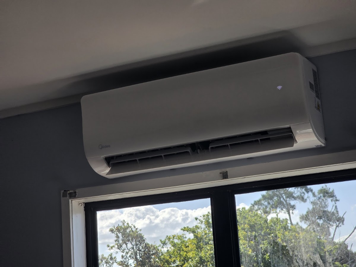 Hi-wall heat pump indoor unit mounted above a window