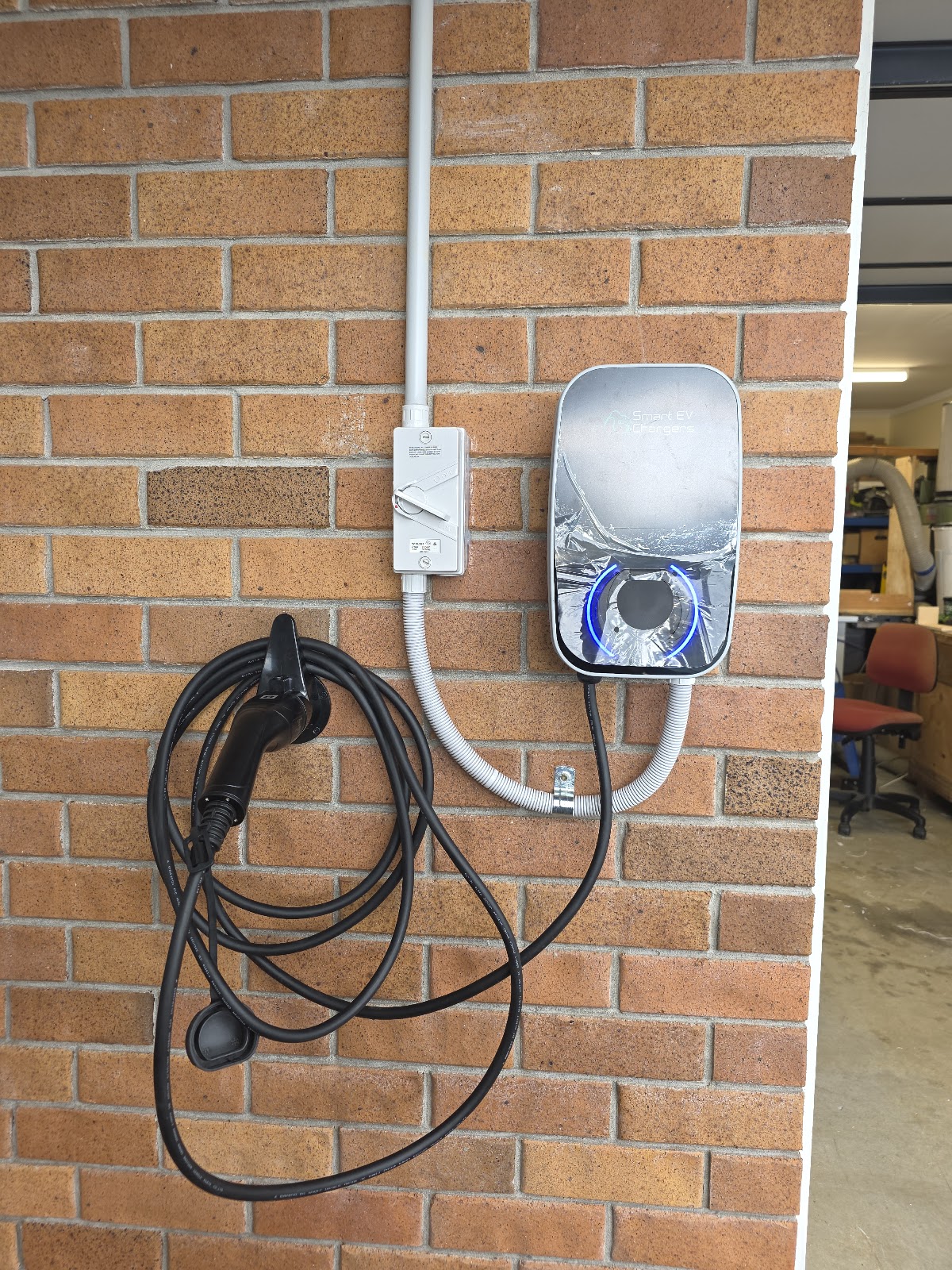 Smart EV charger installed on a brick garage wall