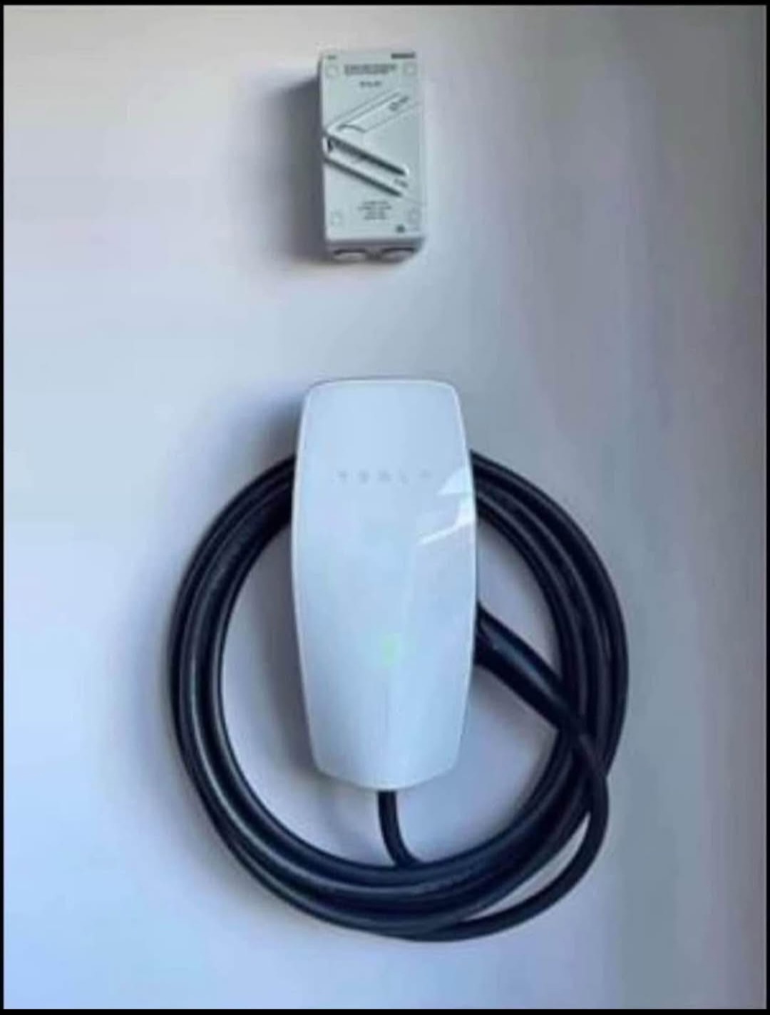 Tesla wall connector installed with cable neatly coiled